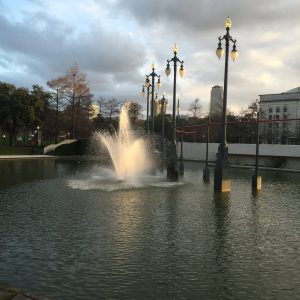 a fountain in front of a body of water