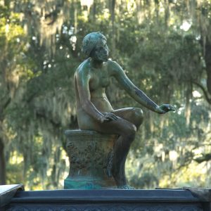 a statue of a person sitting in a tree